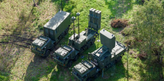 IRIS-T SLM key system components viewed from above, consisting of the command post (left), transporter, erector, launcher (TEL; middle), and radar (right). This system forms the MRAD component of ESSI. [Diehl Defence]