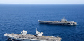 The UK aircraft carrier HMS Prince of Wales (foreground) sails alongside the US carrier USS George Washington during Australia’s ‘Talisman Sabre’ exercise in July 2025. The two carrier strike groups (CSGs), plus Australian Navy assets, conducted CSG integration activities. [Crown copyright 2025]