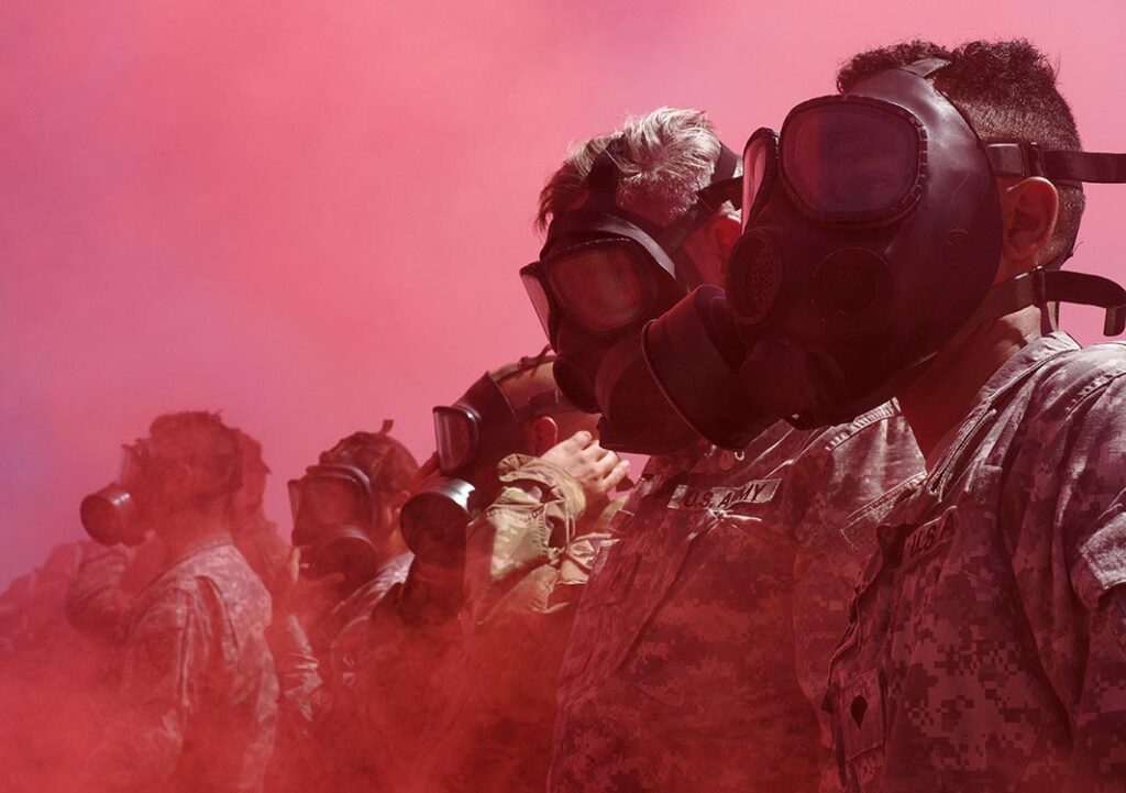 Arizona Army National Guard Soldiers from the 2220th Transportation Company are engulfed by coloured smoke after putting on their protective masks during a simulated chemical attack on 5 August 2017 at Florence Military Reservation in Florence, Arizona. (US ARNG/SSgt Brian A. Barbour)